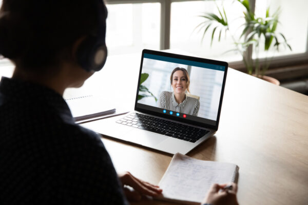 Back View Of Female Employee Sit At Desk At Home